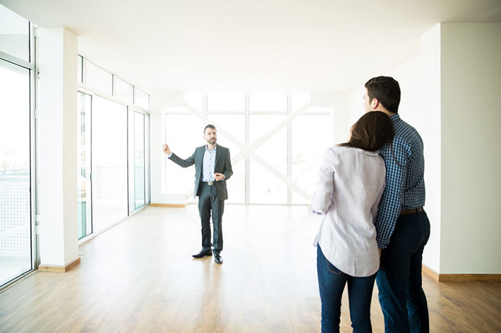 Realtor Showing New House To Loving Couple